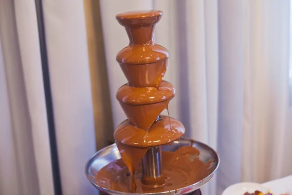 Vibrant Picture of Chocolate Fountain Fontain on childen kids birthday party with a kids playing around and marshmallows and fruits dip dipping into fountain — Stock Photo, Image