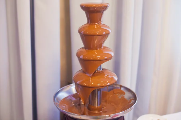 Vibrant Picture of Chocolate Fountain Fontain on childen kids birthday party with a kids playing around and marshmallows and fruits dip dipping into fountain — Stock Photo, Image