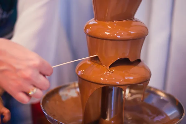 Vibrant Picture of Chocolate Fountain Fontain on childen kids birthday party with a kids playing around and marshmallows and fruits dip dipping into fountain — Stock Photo, Image