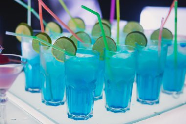 Güzel satır satır farklı renkli alkol kokteyller bir Noel partisi, martini, votka ve diğer nane ile catering buket masada açık hava olay, resim güzel bokeh ile dekore edilmiştir.