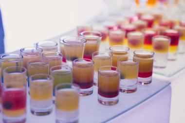 Güzel satır satır farklı renkli alkol kokteyller ile dekore edilmiş catering buket masada açık hava olay üzerinde Noel partisi, martini, votka ve diğerleri nane