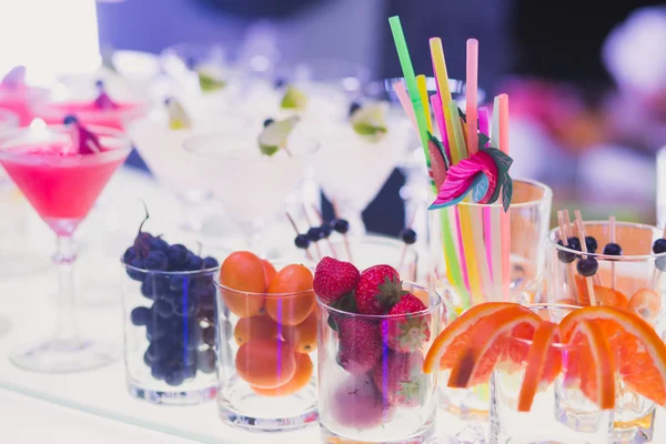 Mooie rijlijn verschillende gekleurde alcohol cocktails met mint op een kerstfeest, martini, wodka en anderen op ingericht horeca boeket tabel op openlucht evenement, foto met mooie bokeh — Stockfoto