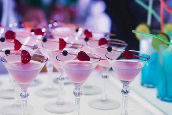 Piękny wiersz wiersz inny alkohol kolorowe koktajle z mięty na bożonarodzeniowe, martini, wódka, a inni zdobione cateringu tabela bukiet na festiwalu open air — Zdjęcie stockowe