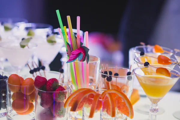 Hermosa línea de fila de cócteles de alcohol de diferentes colores con menta en una fiesta de Navidad, martini, vodka y otros en la mesa de ramo de catering decorado en el evento al aire libre —  Fotos de Stock