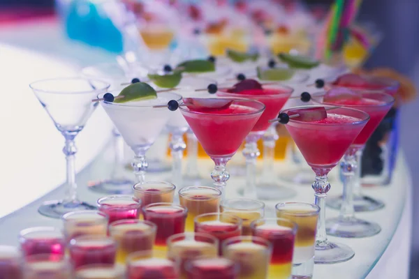 Piękny wiersz wiersz inny alkohol kolorowe koktajle z mięty na bożonarodzeniowe, martini, wódka, a inni zdobione cateringu tabela bukiet na festiwalu open air — Zdjęcie stockowe