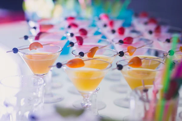 Hermosa línea de fila de cócteles de alcohol de diferentes colores con menta en una fiesta de Navidad, martini, vodka y otros en la mesa de ramo de catering decorado en el evento al aire libre — Foto de Stock
