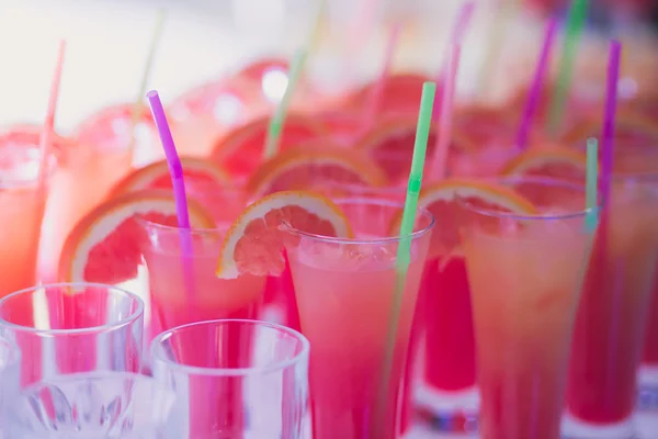 Красивая линия рядов разноцветных алкогольных коктейлей с мятой на рождественской вечеринке, мартини, водки и другие на украшенном букетном столе на открытом воздухе — стоковое фото