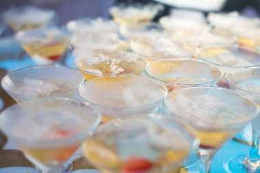 Güzel satır satır farklı renkli alkol kokteyller bir Noel partisi, martini, votka ve diğer nane ile catering buket masada açık hava olay, resim güzel bokeh ile dekore edilmiştir.