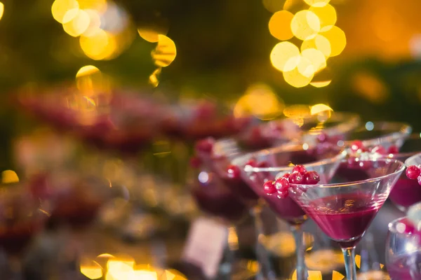 Hermosa línea de fila de cócteles de alcohol de diferentes colores con menta en una fiesta de Navidad, martini, vodka y otros en la mesa de ramo de catering decorado en el evento al aire libre, foto con hermoso bokeh —  Fotos de Stock