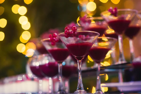 Krásný řádek z různých barevných alkohol koktejly s mátou na vánoční večírek, martini, vodku a jiné na zdobené stravování kytice tabulka na open air akce, obrázek s krásný bokeh — Stock fotografie