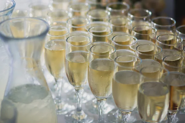 Belle ligne de rangées de différents cocktails alcoolisés colorés à la menthe lors d'une fête de Noël, martini, vodka et autres sur une table de bouquet décorée en plein air, photo avec un beau bokeh — Photo