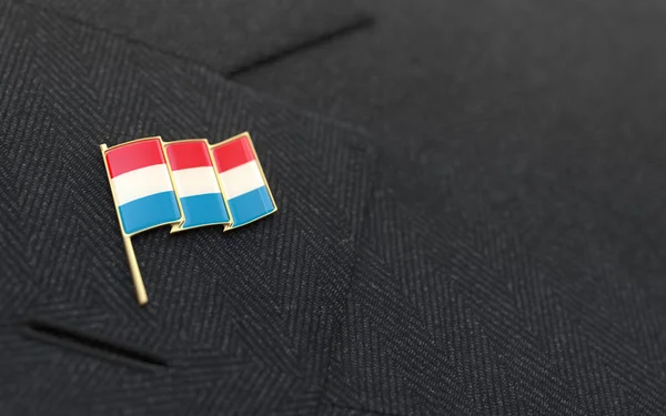 Luxembourg flag lapel pin on the collar of a business suit — Stock Photo, Image