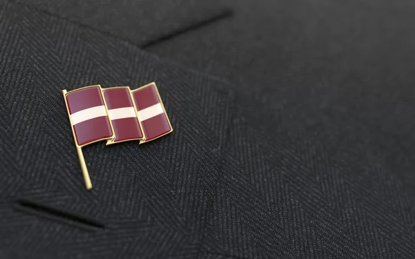 Latvia flag lapel pin on the collar of a business suit — Stock Photo, Image