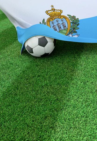Футбольный мяч и национальный флаг Сан-Марино, зеленая трава — стоковое фото