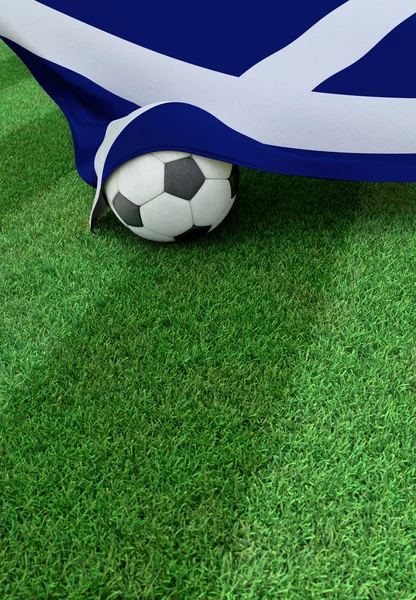 Fotbalový míč a státní vlajka Skotska, zelené trávy — Stock fotografie