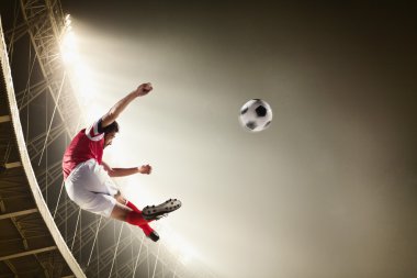 Stadyumda futbol topu tekmeleme atlet
