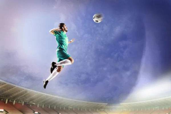 Atleta encabezando la pelota de fútbol en el estadio — Foto de Stock
