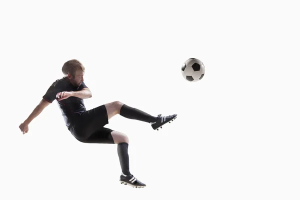 Спортсмен кидає футбольний м'яч — стокове фото