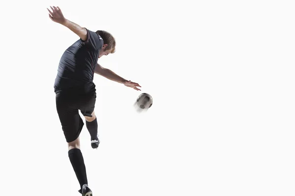 Atleta pateando pelota de fútbol — Foto de Stock