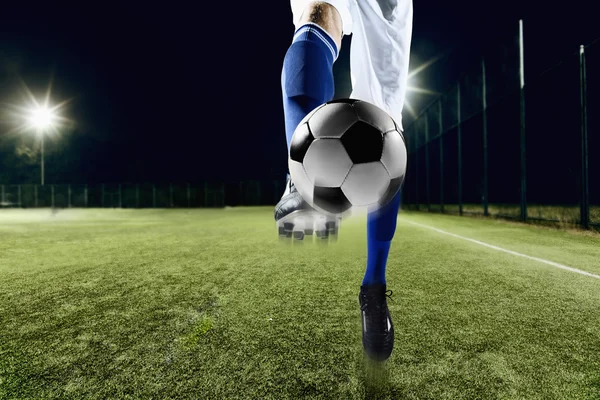 Athlete kicking soccer ball — Stock Photo, Image