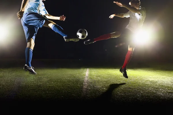 Dos futbolistas pateando una pelota de fútbol — Foto de Stock