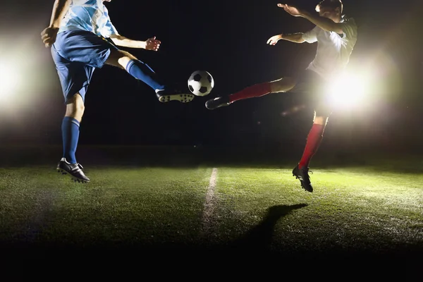 Twee voetballers schoppen van een voetbal — Stockfoto