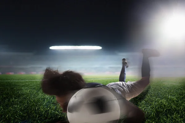 Футболист, возглавляющий футбольный мяч — стоковое фото