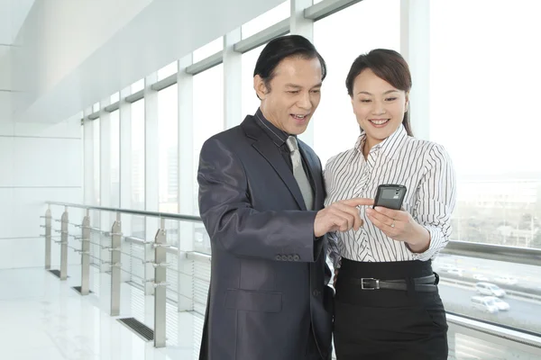 Affärsmannen och affärskvinna söker en telefon — Stockfoto