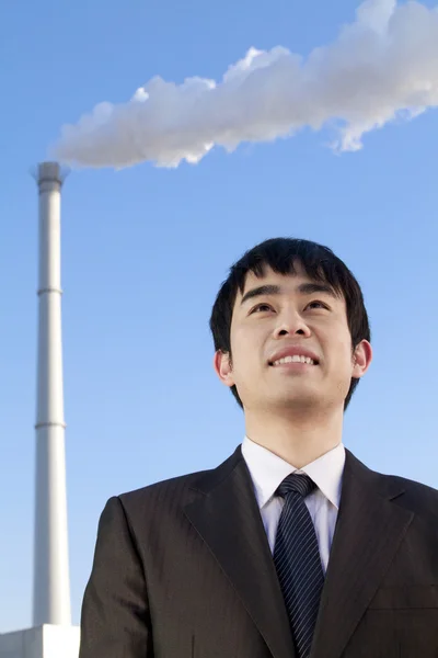 Businessman in Front of Smokestack — Stock Photo, Image