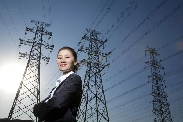 Businesswoman in front of power lines — Stock Photo, Image