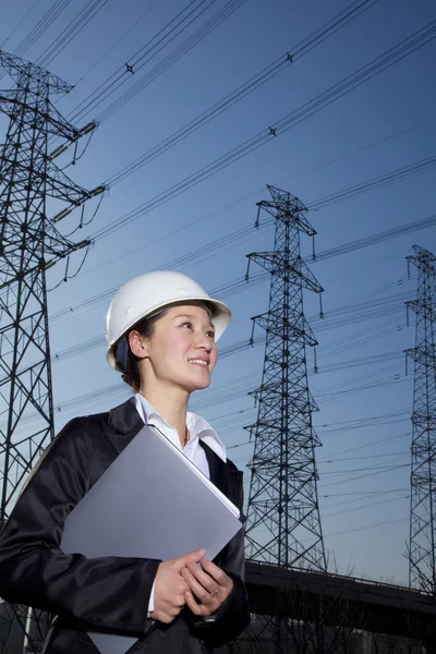Businesswoman in front of power lines — Stock Photo, Image