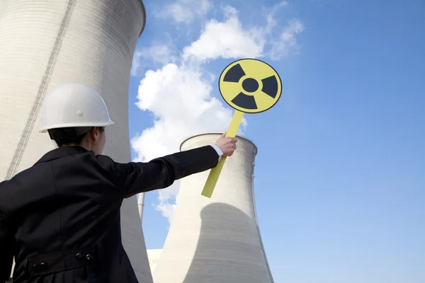 Engineer in front of cooling towers with sign — Stock Photo, Image