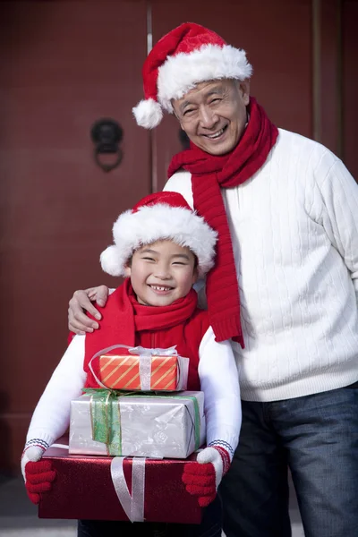 Дедушка и внук держат рождественские подарки — стоковое фото