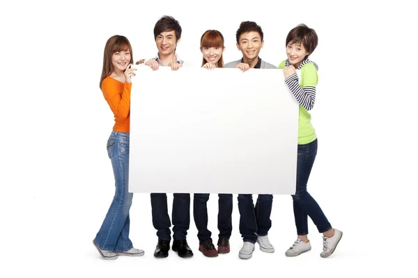 Bir grup genç insan boş bir tabela holding — Stok fotoğraf