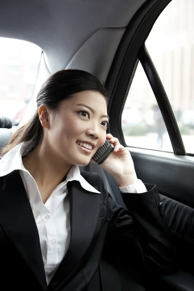 Affärskvinna i en bil på telefonen — Stockfoto