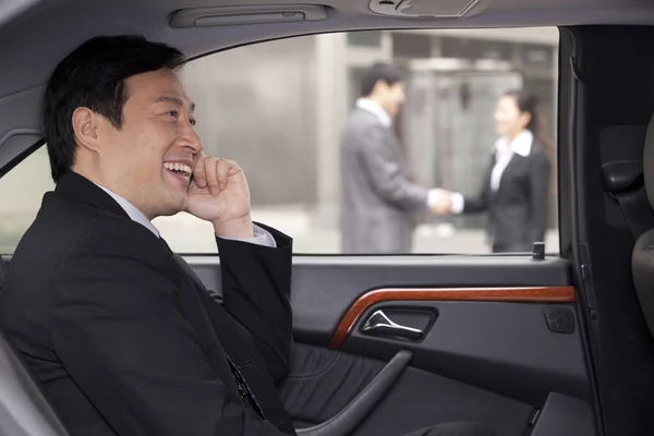 Businessman talking on phone in car — Stock Photo, Image