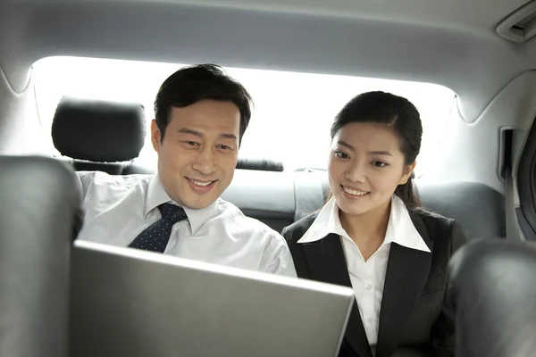 Business people working with laptop in the car — Stock Photo, Image