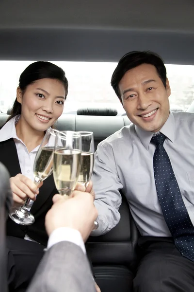 Business people toasting in back of car — Stock Photo, Image