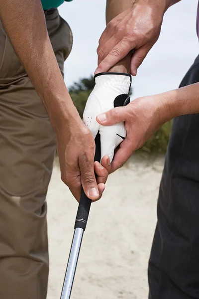 Два человека держат клюшку для гольфа — стоковое фото