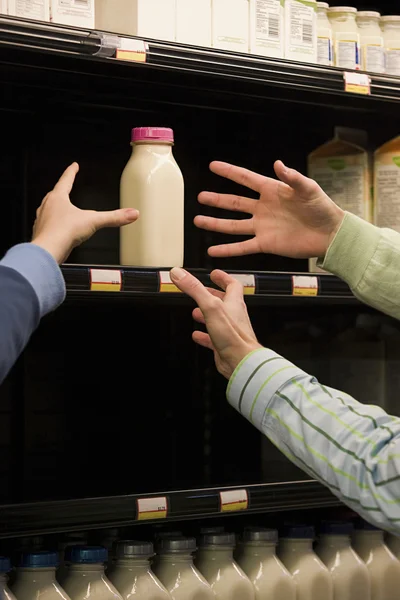 People reaching for milk — Stock Photo, Image