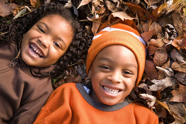 Kinderen liggend op Bladeren — Stockfoto