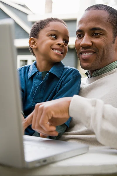 Pai e filho usando laptop — Fotografia de Stock