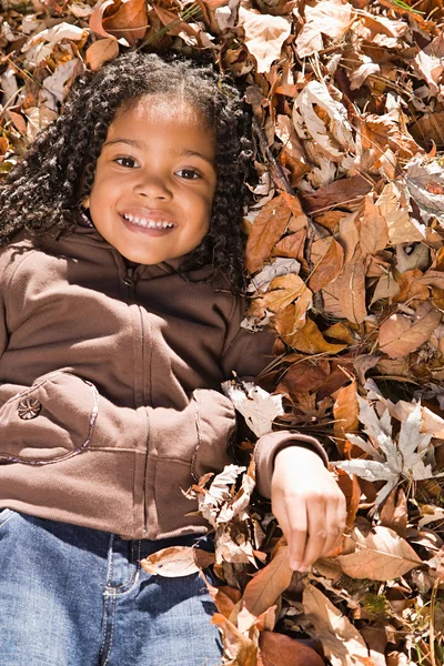 Girl lying in leaves — Stock Photo, Image