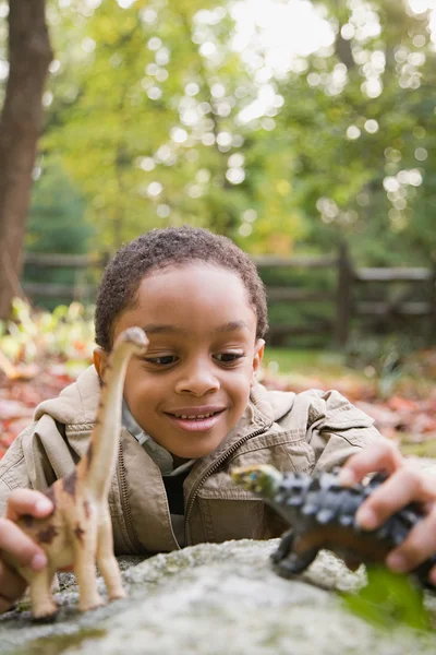 Niño jugando con dinosaurios de juguete —  Fotos de Stock