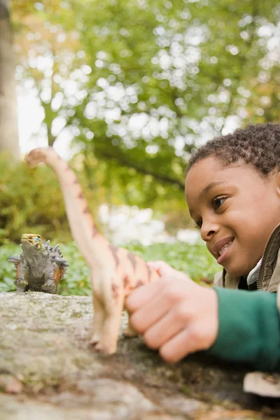 Menino brincando com dinossauros de brinquedo — Fotografia de Stock