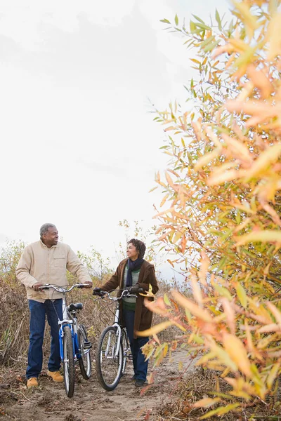 Una pareja empujando bicicletas —  Fotos de Stock