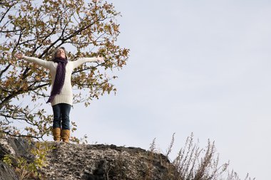 Kayaların üzerinde duran neşeli kadın