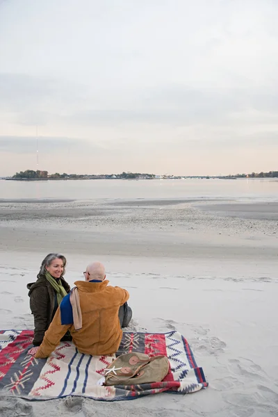 Ouder paar rusten op het strand — Stockfoto