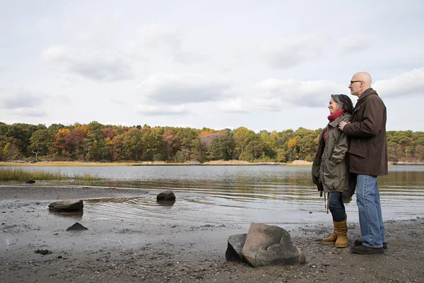 Coppia matura guardando un lago — Foto Stock