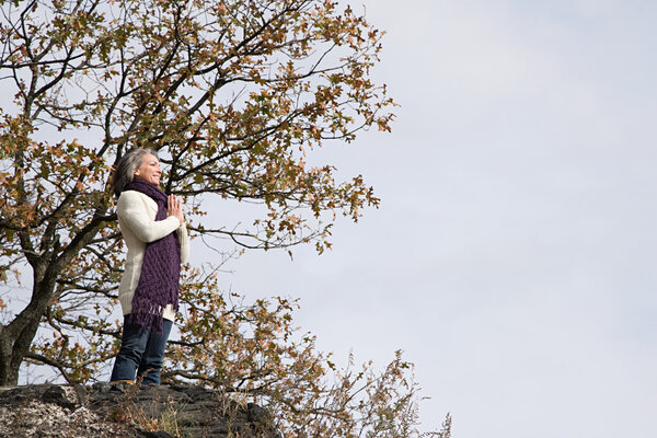 Woman praying on a rock
